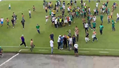 في مشهد غريب.. مئات المشجعين يقتحمون الملعب للاعتداء على لاعبي فريقهم (فيديو)